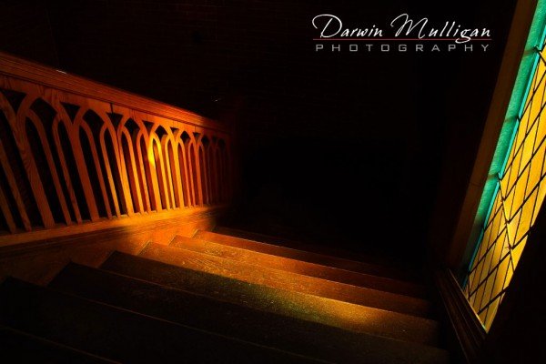 Sunlight streams through stained glass, detail on stairs in church