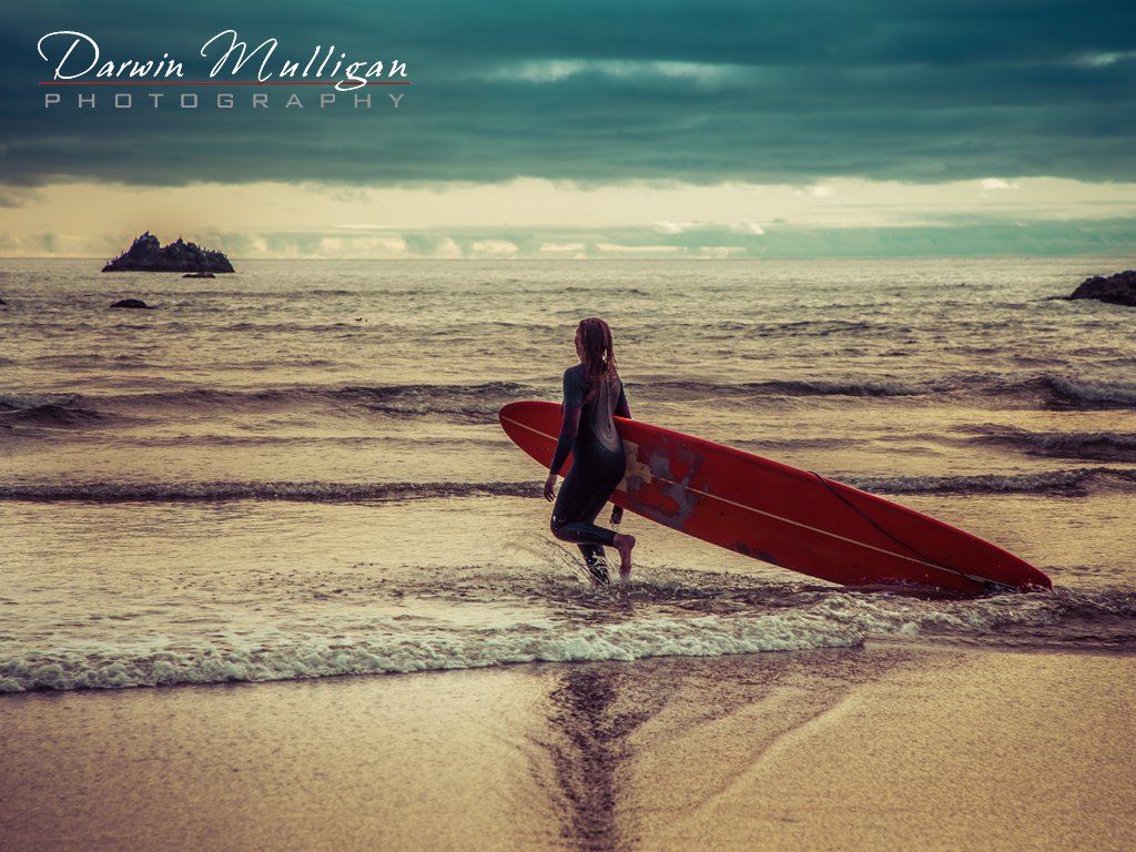 Surfer girl at sunset at Cannon Beach on the Oregon Coast